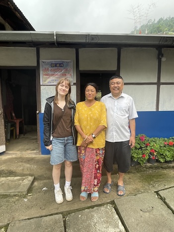 Katherine standing with their host family in front of their home in Gorkhe Village